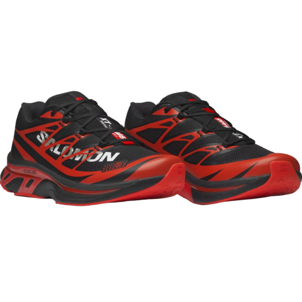 Pair of black and red Salomon running shoes facing forward, showing rugged red and black soles and laced uppers