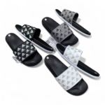 Assorted Adidas slide sandals in black, white, and gray with the brand logo on the straps, laid out on a white background.