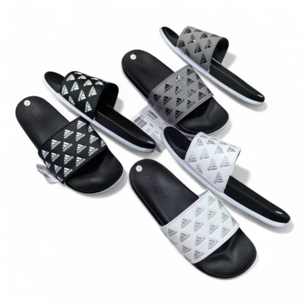 Assorted Adidas slide sandals in black, white, and gray with the brand logo on the straps, laid out on a white background.