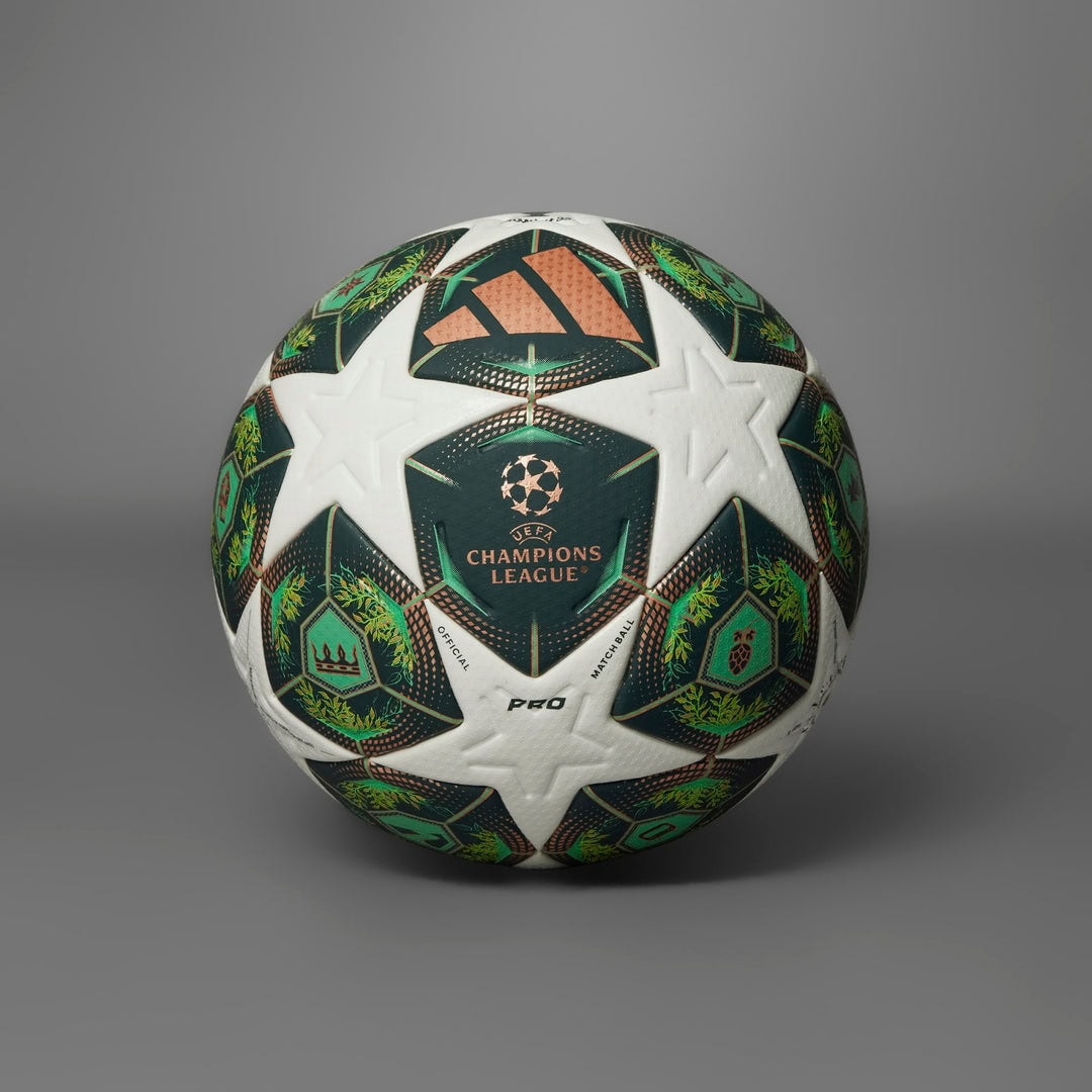 rn-image_picker_lib_temp_5c6c9ad3-0b9a-4b07-ab21-6b519a4cce91 | UAE SPORT STORE Soccer ball with green, white, and copper panels featuring the UEFA Champions League logo at the center and star patterns.