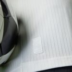 rn-image_picker_lib_temp_6231cdbc-b134-4f2f-9c4b-95c00f10d206 | UAE SPORT STORE Close-up of light gray car seat fabric with a stitched Adidas badge.