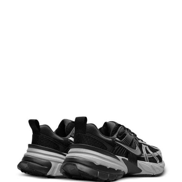 Black athletic sneakers with a chunky gray sole, shown from a rear-side angle.