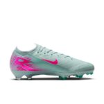 Teal Nike soccer cleat with pink swoosh and geometric heel pattern, side profile, firm-ground studs visible.