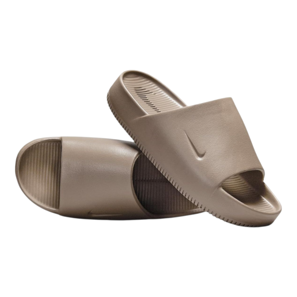 Close-up of two taupe slide sandals with wide strap and textured footbeds on a white background