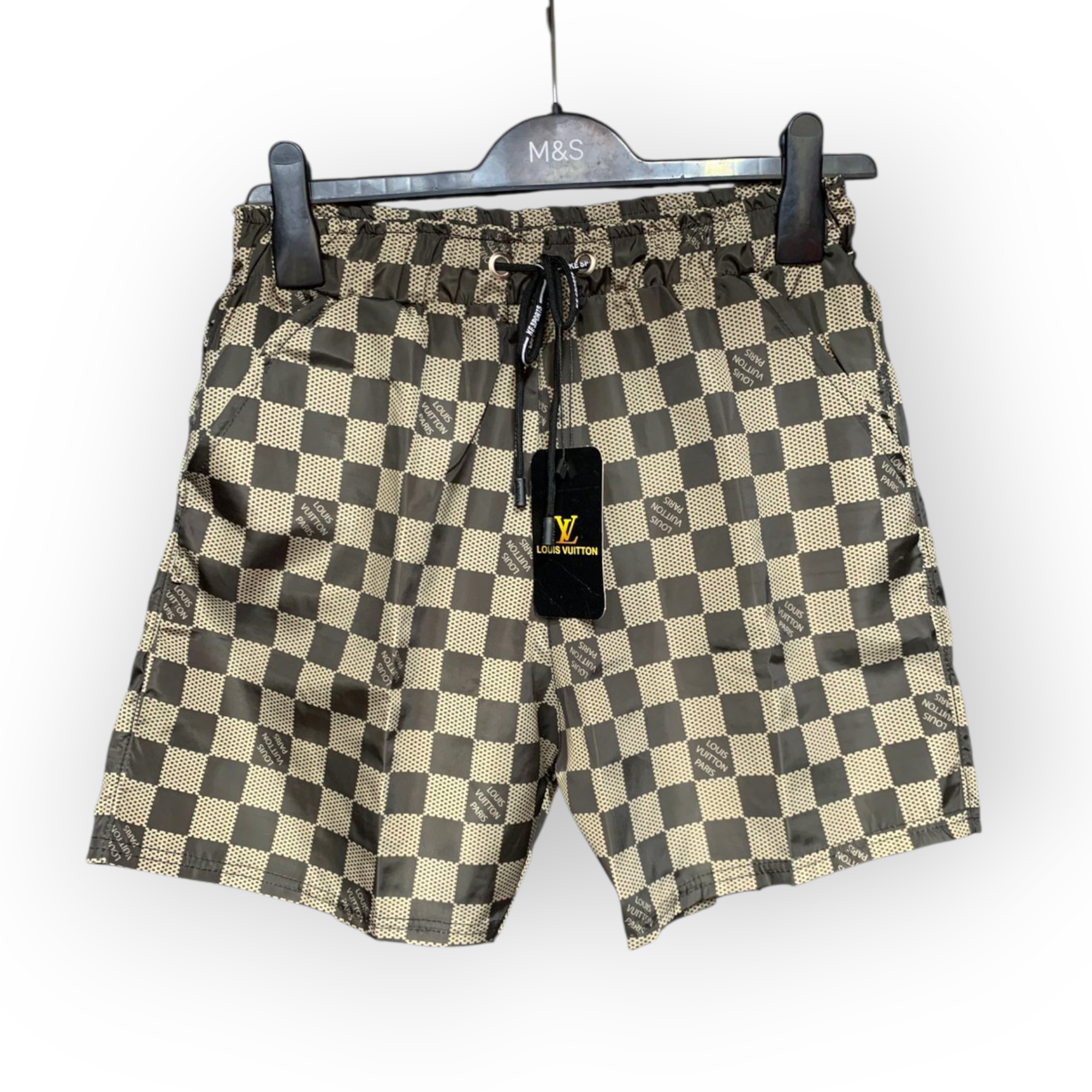 rn-image_picker_lib_temp_730b1534-d481-402f-b26c-897f1785ab50 Louis Vuitton checkerboard shorts hanging on a black hanger with a drawstring waistband and tag visible.