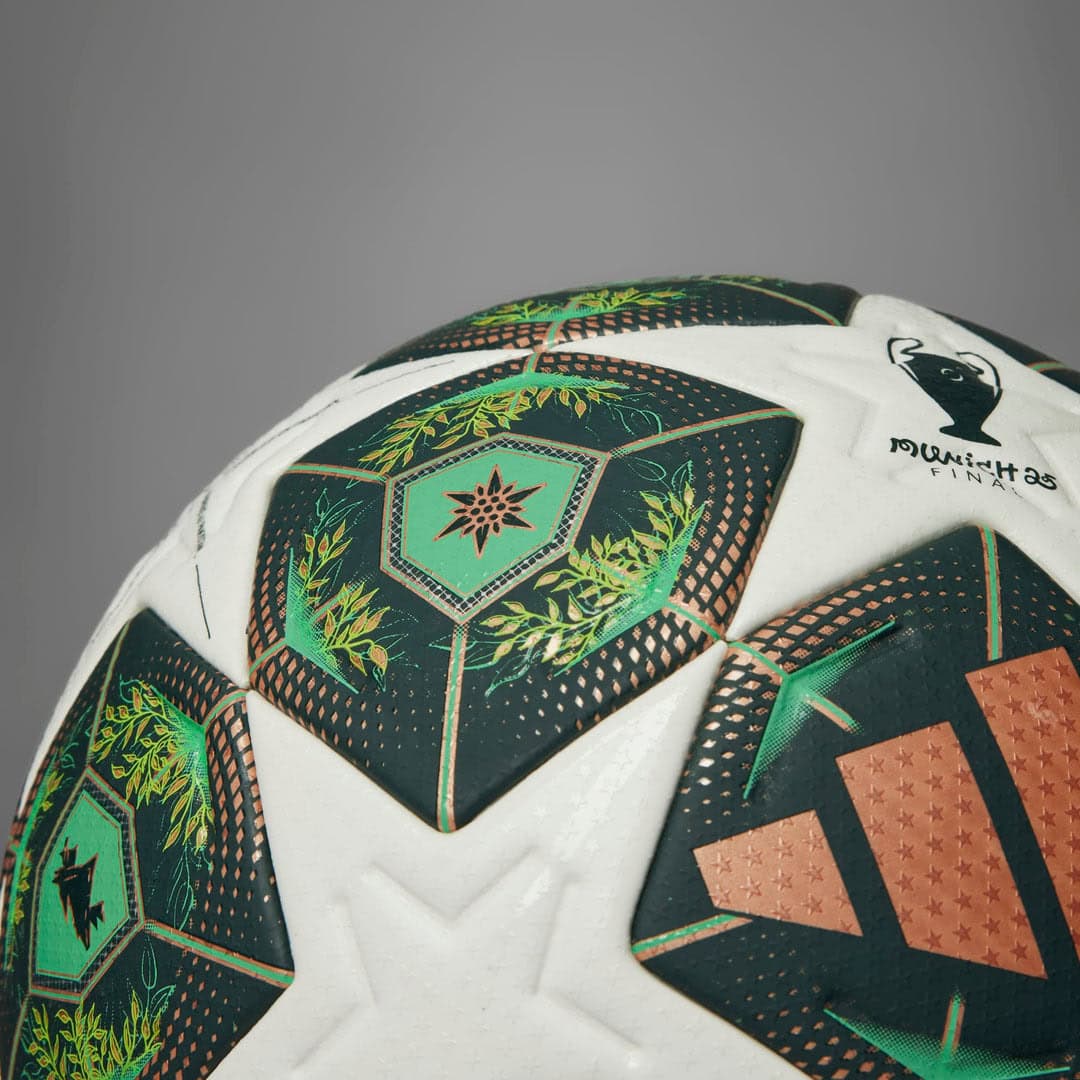 rn-image_picker_lib_temp_770a7320-fee8-44f7-89fb-a74ea3ff1549 | UAE SPORT STORE Close-up of a soccer ball with green hexagonal panels and leaf-patterned designs on a white surface.