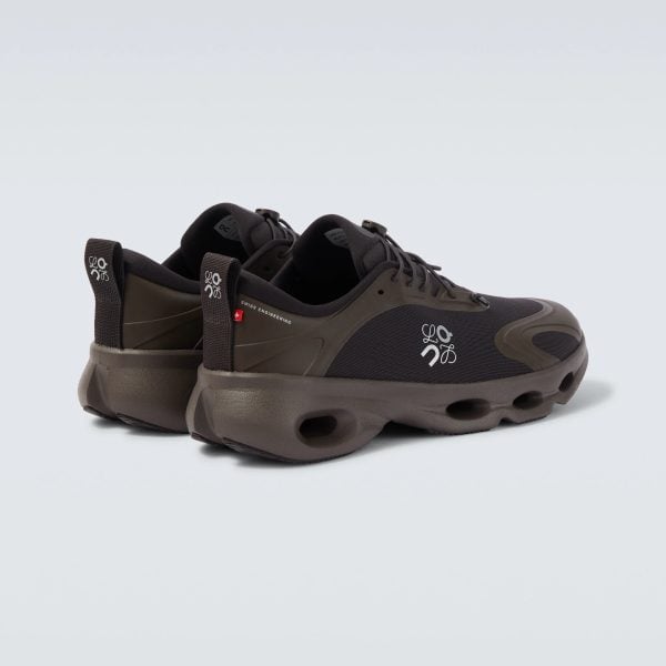 Partial view of brown hiking sneaker showing laces and sole on a pale background.