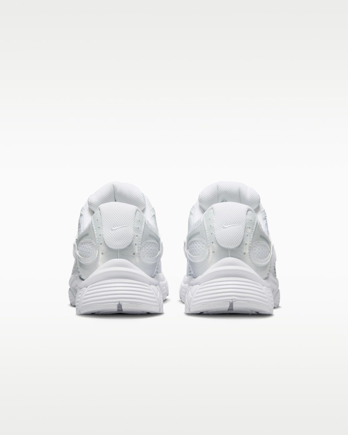 Front view of two white athletic sneakers placed side by side on a pale gradient background.