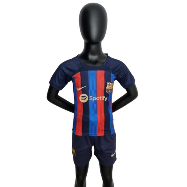 Black mannequin wearing FC Barcelona home jersey with blue and red vertical stripes against a white background.