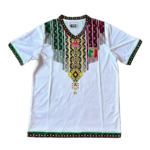 White dashiki-style tunic with multicolor geometric embroidery around the V-neck and sleeves, white body, and a shield emblem on the left chest.