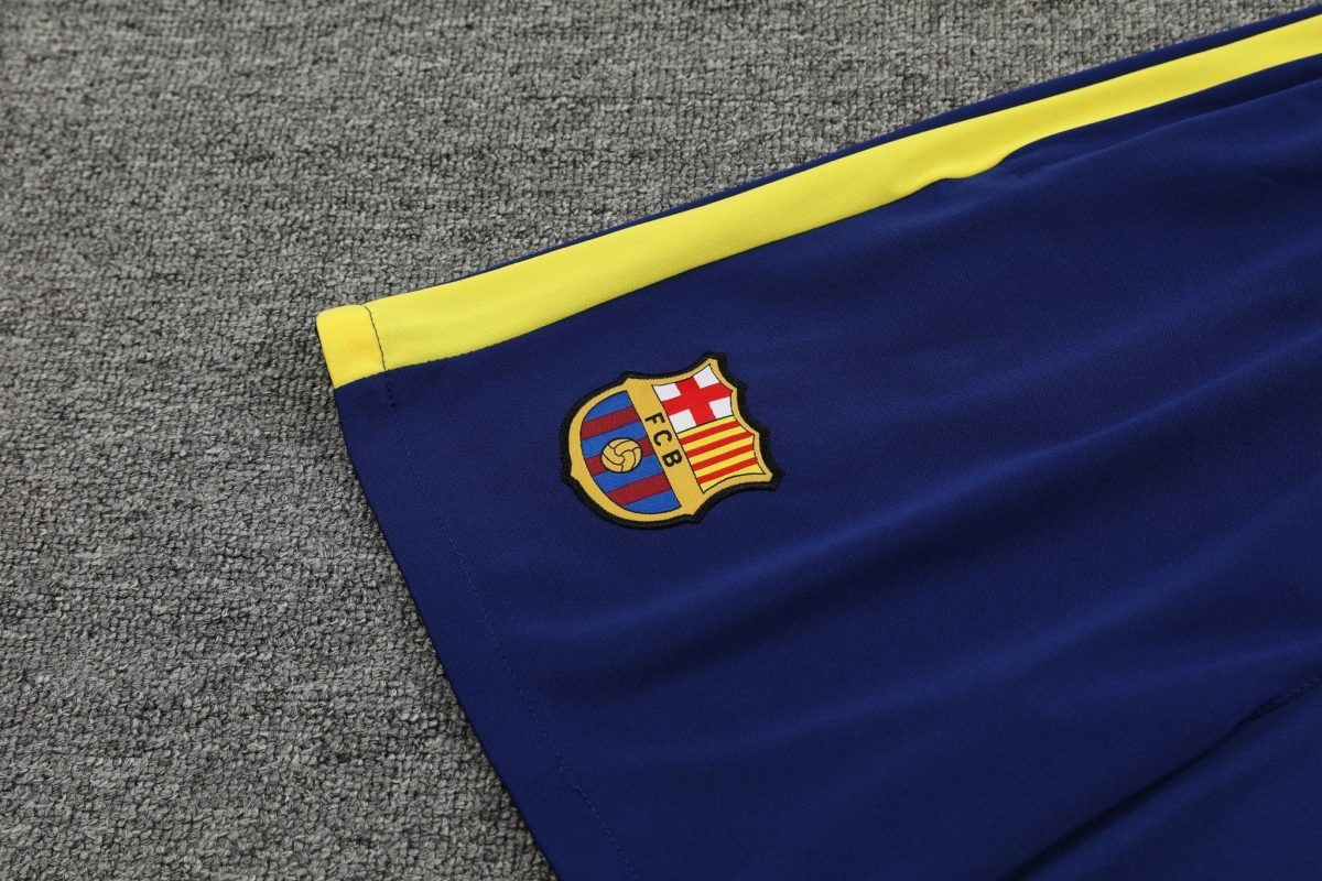 Blue FC Barcelona flag with yellow stripe laid on a gray carpet, crest visible in the corner.
