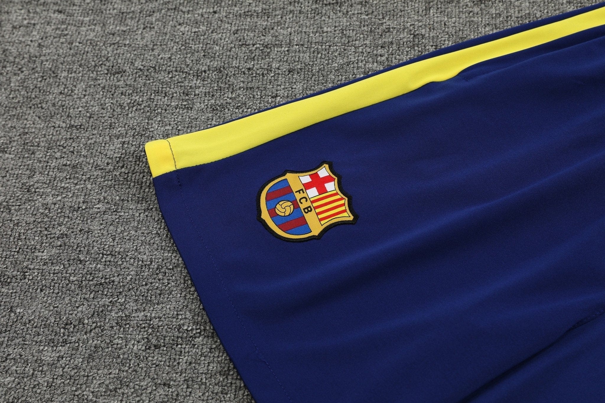 rn-image_picker_lib_temp_88667d5f-2018-4941-b2d5-d4f11545a0b3 | UAE SPORT STORE Blue FC Barcelona flag with yellow stripe laid on a gray carpet, crest visible in the corner.