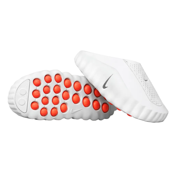 White Nike running shoes with a red outsole pod grip pattern and textured sole surface.