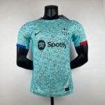 Mannequin wearing a turquoise Barça football jersey with a black Spotify logo across the chest and the FC Barcelona crest on the left breast area, posed against a plain background.