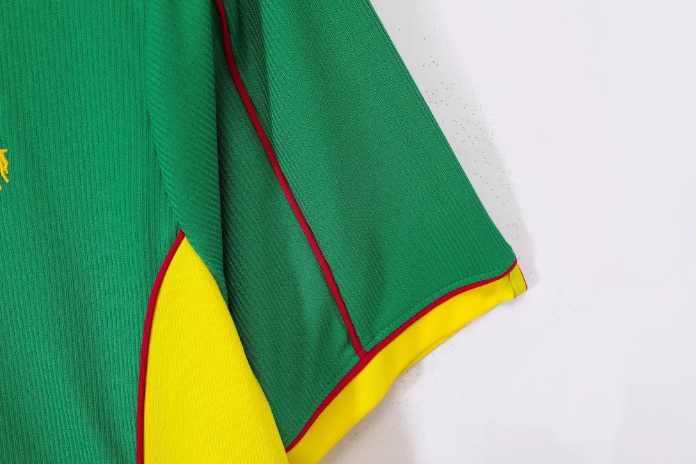 rn-image_picker_lib_temp_8d225551-68e3-478d-ba17-87ed4177dfd2 | UAE SPORT STORE Close-up of a green fabric garment with yellow under panel and red piping along the edges, showing a sporty jersey detail.