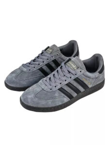 Pair of grey suede Adidas Gazelle sneakers with black stripes and a black sole
