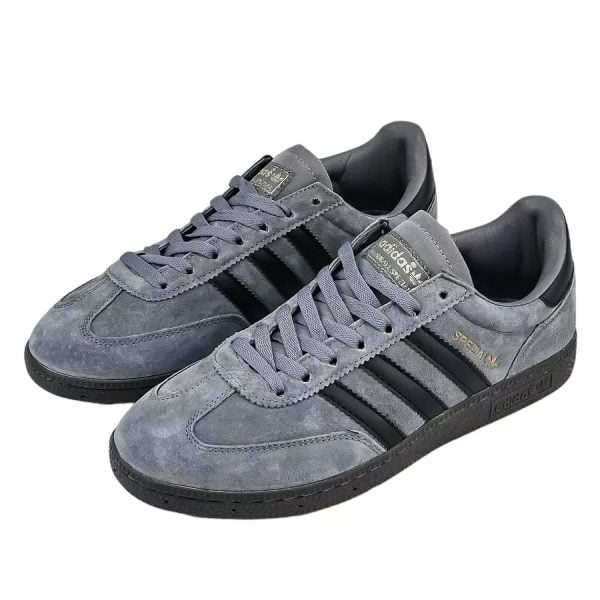 Pair of grey suede Adidas Gazelle sneakers with black stripes and a black sole