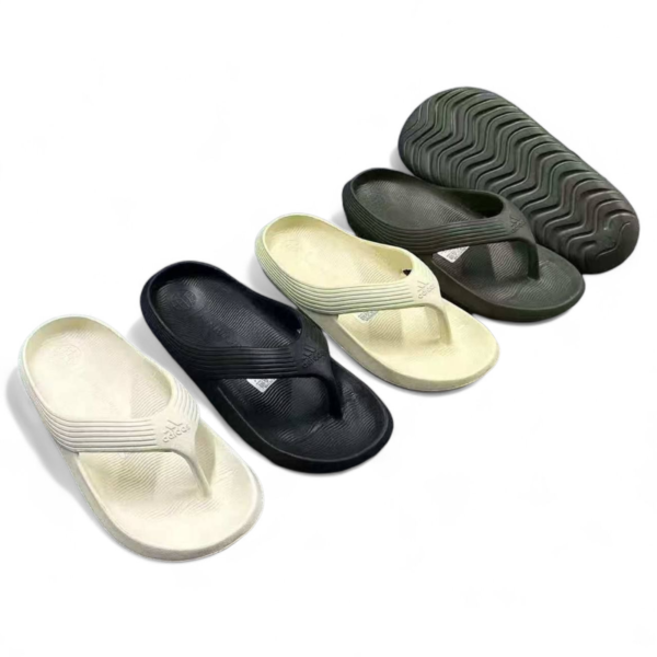 Assorted slide sandals in black and cream with textured soles