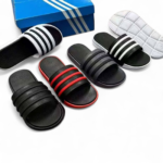 Assorted black and red striped slide sandals arranged with a blue shoebox on a white background