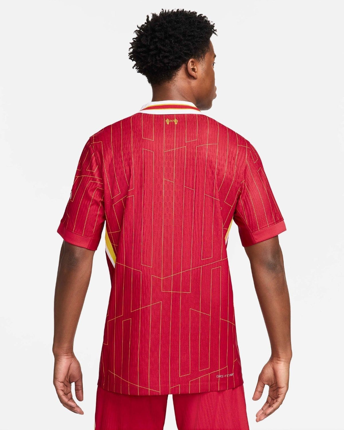 Back view of a person wearing a red geometric-patterned sports jersey with gold lines and a white collar with red/yellow trim against a white background.
