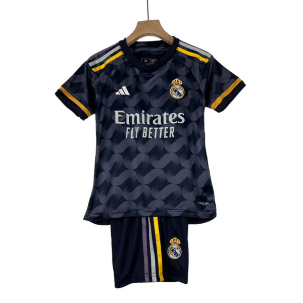 Real Madrid football jersey on a wooden hanger: dark navy with yellow accents and crest, sponsor text visible