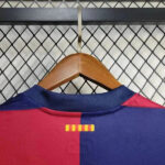 rn-image_picker_lib_temp_99b919ba-e8dd-4f97-9c44-0a6e0d000226 | UAE SPORT STORE Red and blue soccer jersey on a wooden hanger, hanging on a wire mesh rack; a small yellow striped mark sits at the back near the collar.