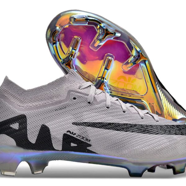 Gray soccer cleat with a large iridescent soleplate reflecting rainbow colors underfoot and protruding studs.**(informative)****