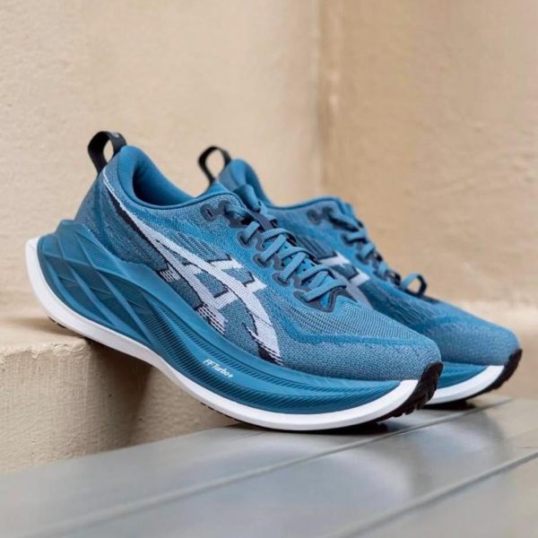 Pair of blue running shoes with white accents resting on a light ledge.