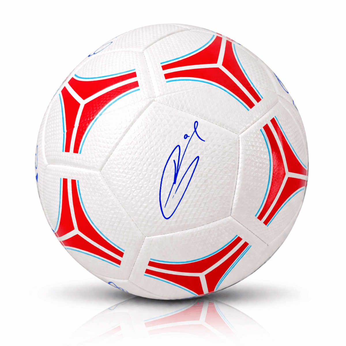 Autographed white soccer ball with red and blue pattern accents and a blue signature on the panels above a soft shadow.