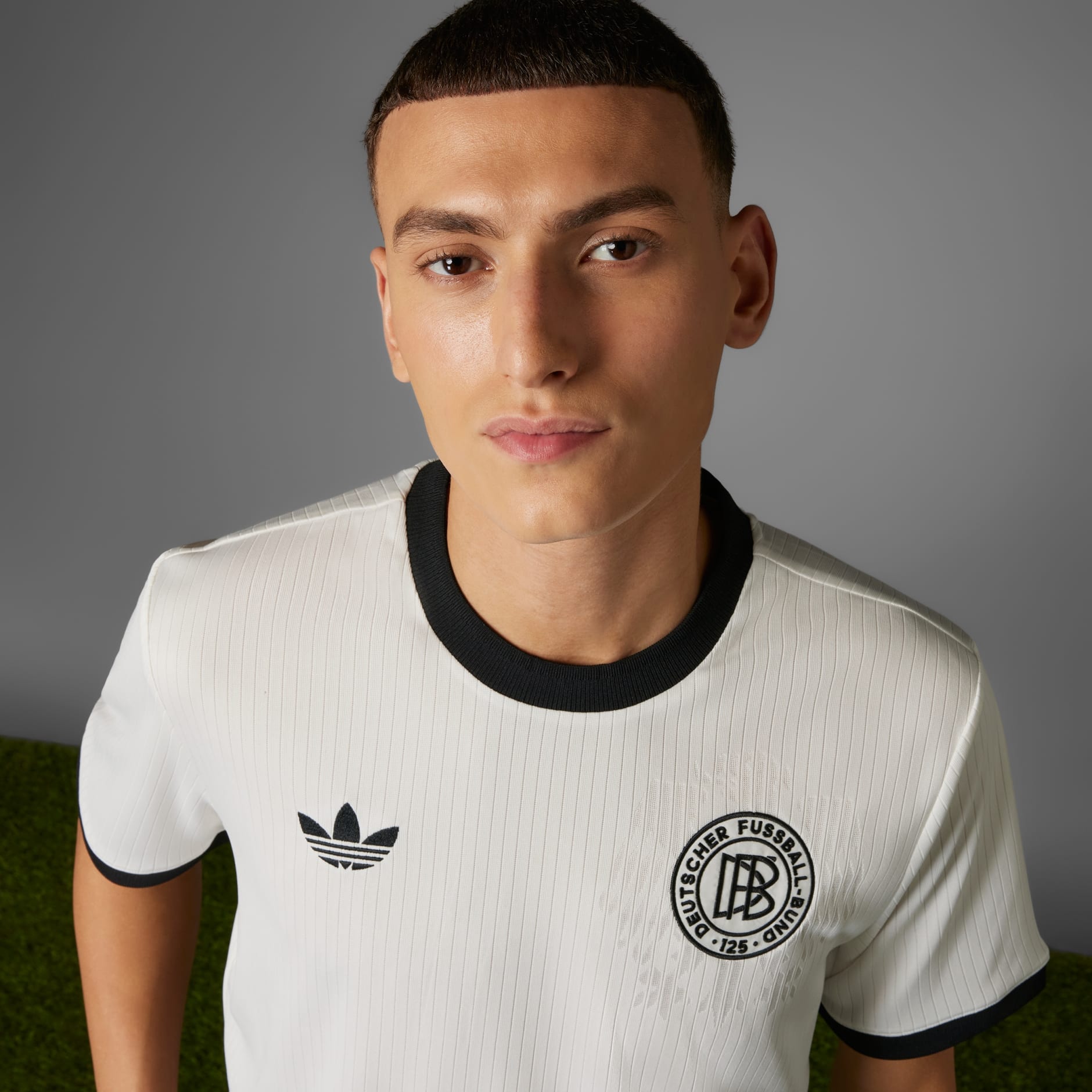 rn-image_picker_lib_temp_a50ebcc3-d44c-4f99-99b9-4bd73e4677a1 | UAE SPORT STORE Close-up of a person wearing a white jersey with black collar, showing Adidas logo and a circular club crest.