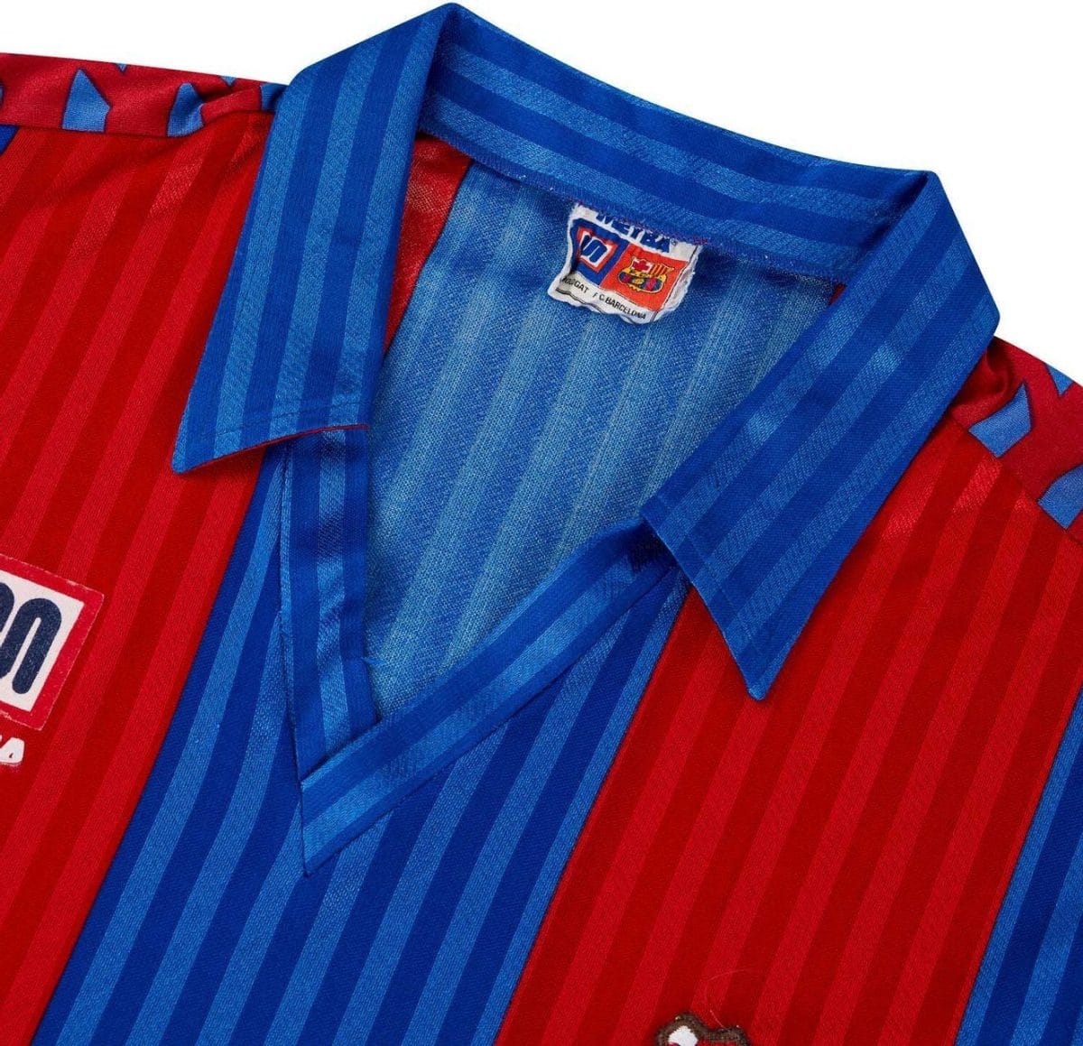 Close-up of a red and blue striped collared shirt with a small FC Barcelona label near the collar