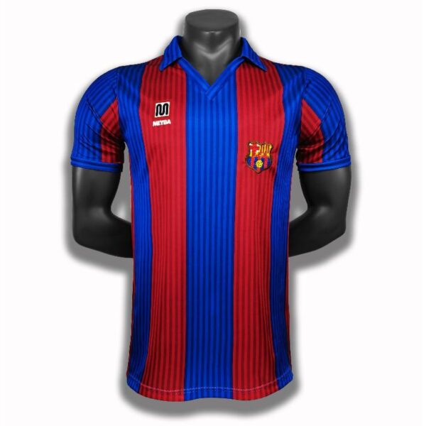 Red and blue vertically striped soccer jersey on a black mannequin, with club crest on the left chest and a sponsor logo on the right chest.