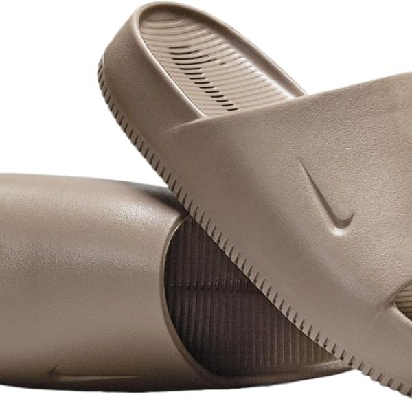 Brown Nike slide sandals with textured footbeds and ribbed outsole, viewed from side.