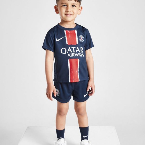 Young boy wearing a navy PSG football kit with Qatar Airways sponsor, standing and smiling. Option 1: A child model in a Paris Saint‑Germain soccer jersey and shorts.