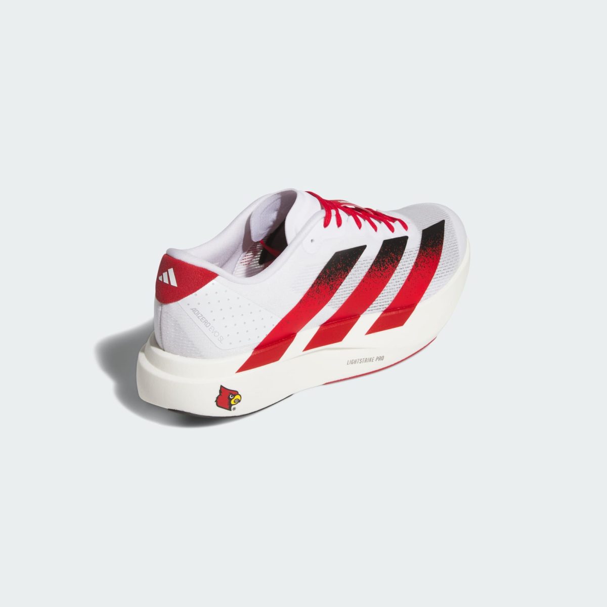 White athletic sneaker with red diagonal stripes on the side, shown from a close-up angle
