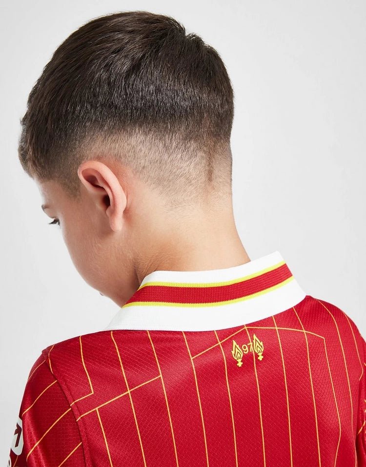 rn-image_picker_lib_temp_c1a1c180-dbab-4ba1-90e7-0f9c73bb0210 | UAE SPORT STORE Back of a child’s head with a short fade haircut, wearing a red sports jersey with a white collar and yellow trim.