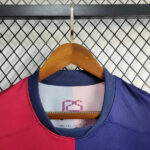 rn-image_picker_lib_temp_c3f67b26-f7da-4069-a59e-54f119d47338 | UAE SPORT STORE Two-tone pink and blue color-block sports jersey on a wooden hanger, with a navy collar.