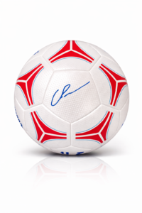 White soccer ball with red and blue decorative panels and a blue autograph on a central panel.