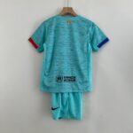 Turquoise sports jersey on a wooden hanger, back view with UNHCR/ACNUR logo and red/blue sleeve cuffs.