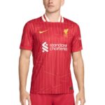 Liverpool FC home jersey in red with gold crest and white 'Standard Chartered' sponsor logo on the chest.