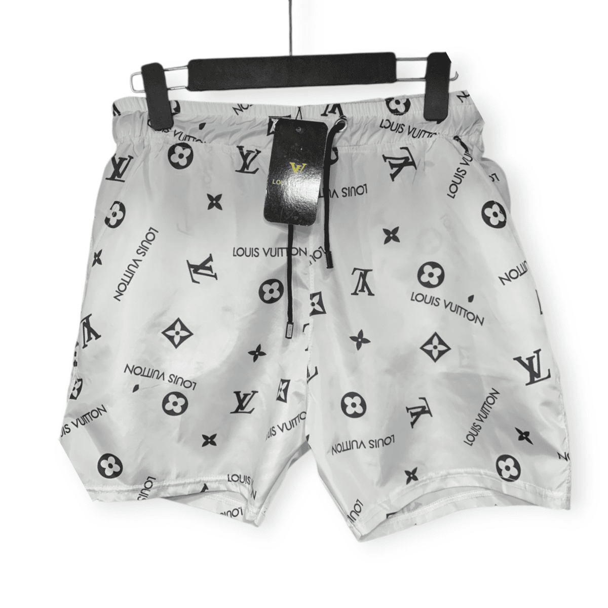 White Louis Vuitton bag with black repeating logo pattern, hanging from a padded horizontal hanger with a black tag attached.