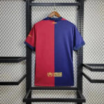 rn-image_picker_lib_temp_d107ab18-465a-4dcf-a678-f4c13ac94f9f | UAE SPORT STORE Back view of a red-and-blue split jersey hanging on a hanger in a metal rack; UNHCR logo at the bottom.