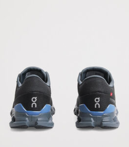 rn-image_picker_lib_temp_d5087a72-6aa5-4631-913f-b8fa9c491fe6 | UAE SPORT STORE Back view of a pair of black running shoes with blue heel accents and the white On logo visible on the heels.