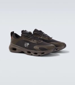 Brown hiking shoe pair shown from a low angle with rugged sole and laces, against a light gray background.