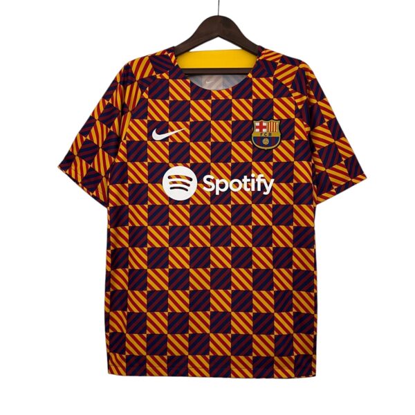 Barcelona football jersey on hanger with red-yellow checker pattern, featuring Nike swoosh and FC Barcelona crest (Spotify sponsor visible).
