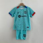 Turquoise FC Barcelona jersey hanging on a wooden hanger, featuring Nike swoosh and Spotify sponsor logo.