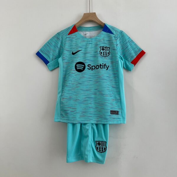 Turquoise FC Barcelona jersey hanging on a wooden hanger, featuring Nike swoosh and Spotify sponsor logo.