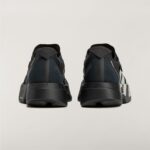 Rear view of two black athletic sneakers standing side by side on a light background with visible heel straps and soles.