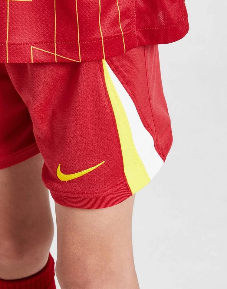 rn-image_picker_lib_temp_e61ff3fc-feb3-4977-9063-2f714e2fd4d5 | UAE SPORT STORE Red athletic shorts with yellow side stripe and a yellow Nike swoosh logo on the leg.