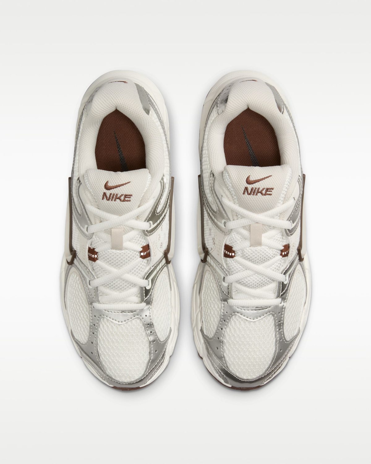 Top-down view of two white Nike sneakers placed side by side on a white background.